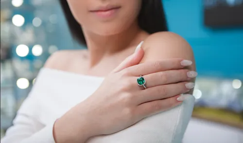 Emerald earrings contrasting festive textiles under varied lighting