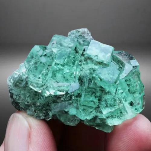 What dress colors make emerald jewelry pop at holiday parties