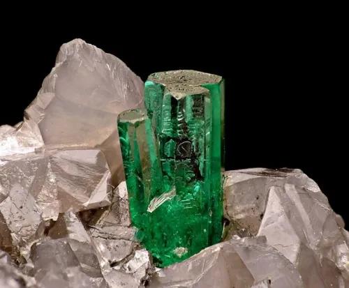 Raw emerald crystals embedded in matrix under daylight